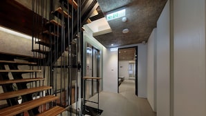 Een modern interieur met een houten trap, glazen deuren en een plafond met een structuur.