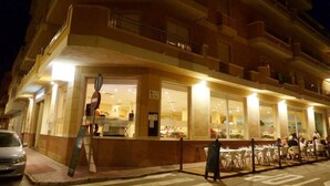 A hotel with multiple floors, large windows, and outdoor seating area. - Aparthotel Sole Bello (Torrevieja)