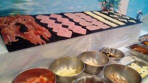 A buffet table with various food items and a decorative backdrop. - Aparthotel Sole Bello (Torrevieja)