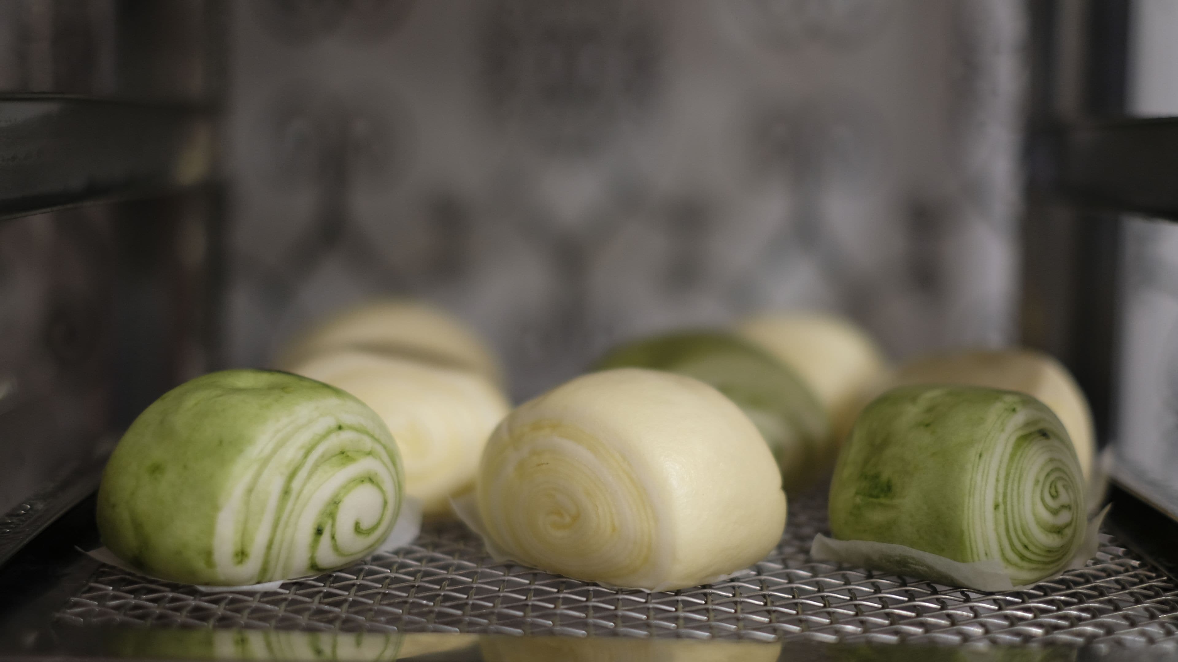 Une cuisine avec un étagère en métal sur laquelle sont disposés plusieurs légumes coupés en tranches.