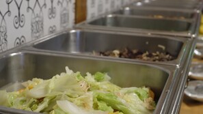 Un buffet proposant divers plats présentés dans des récipients en métal.