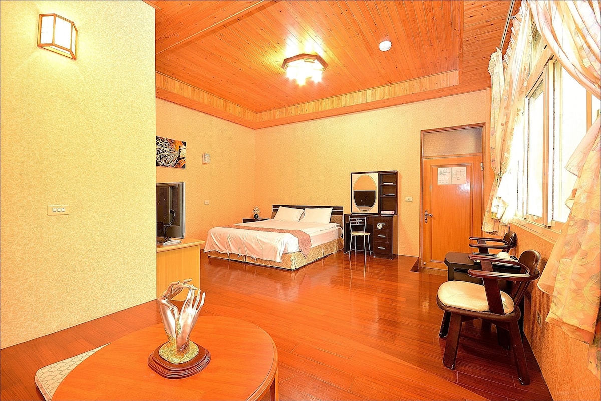 A room with a bed, desk, chair, and a dining table.