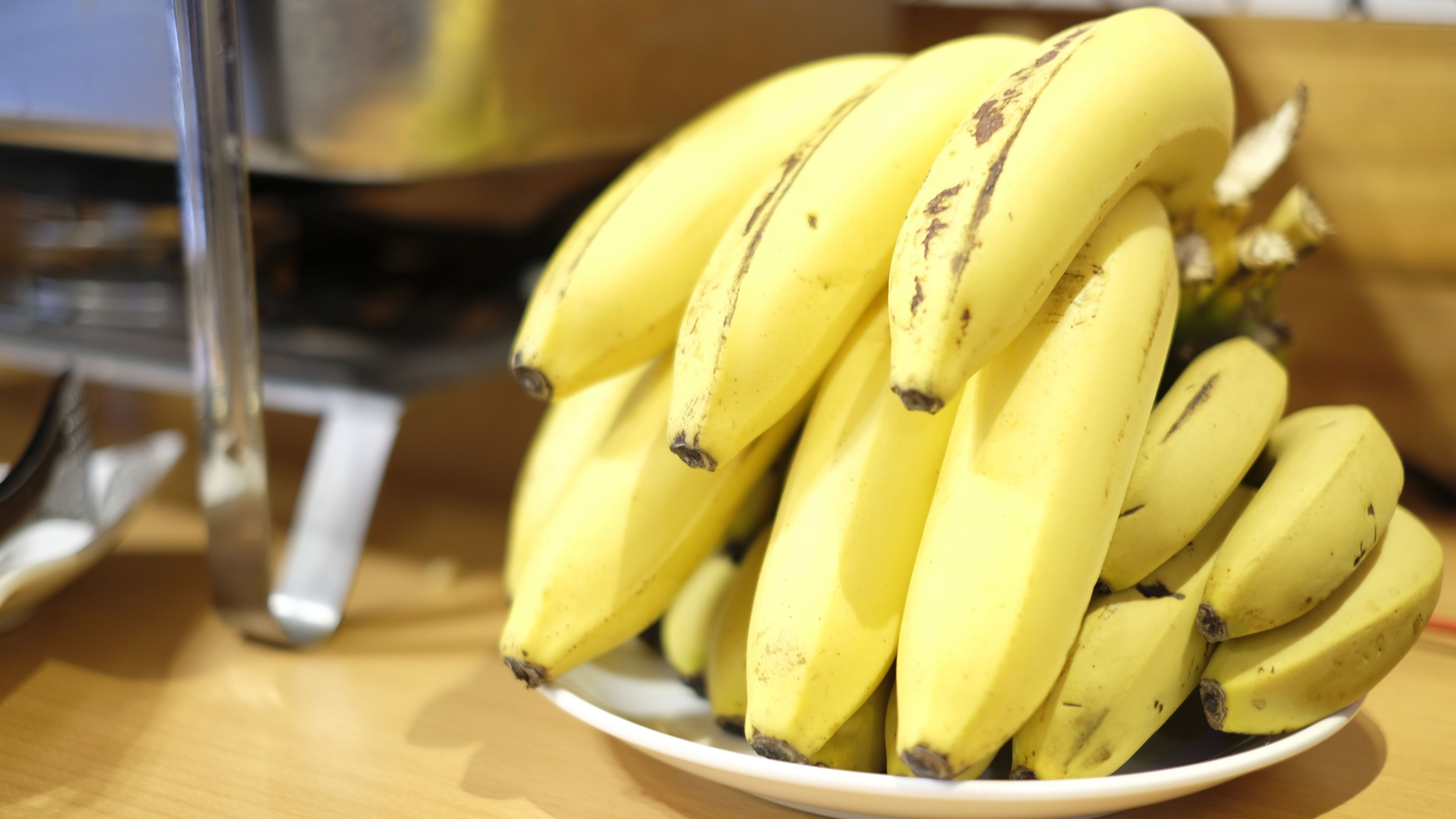 A bowl of bananas on a wooden table.