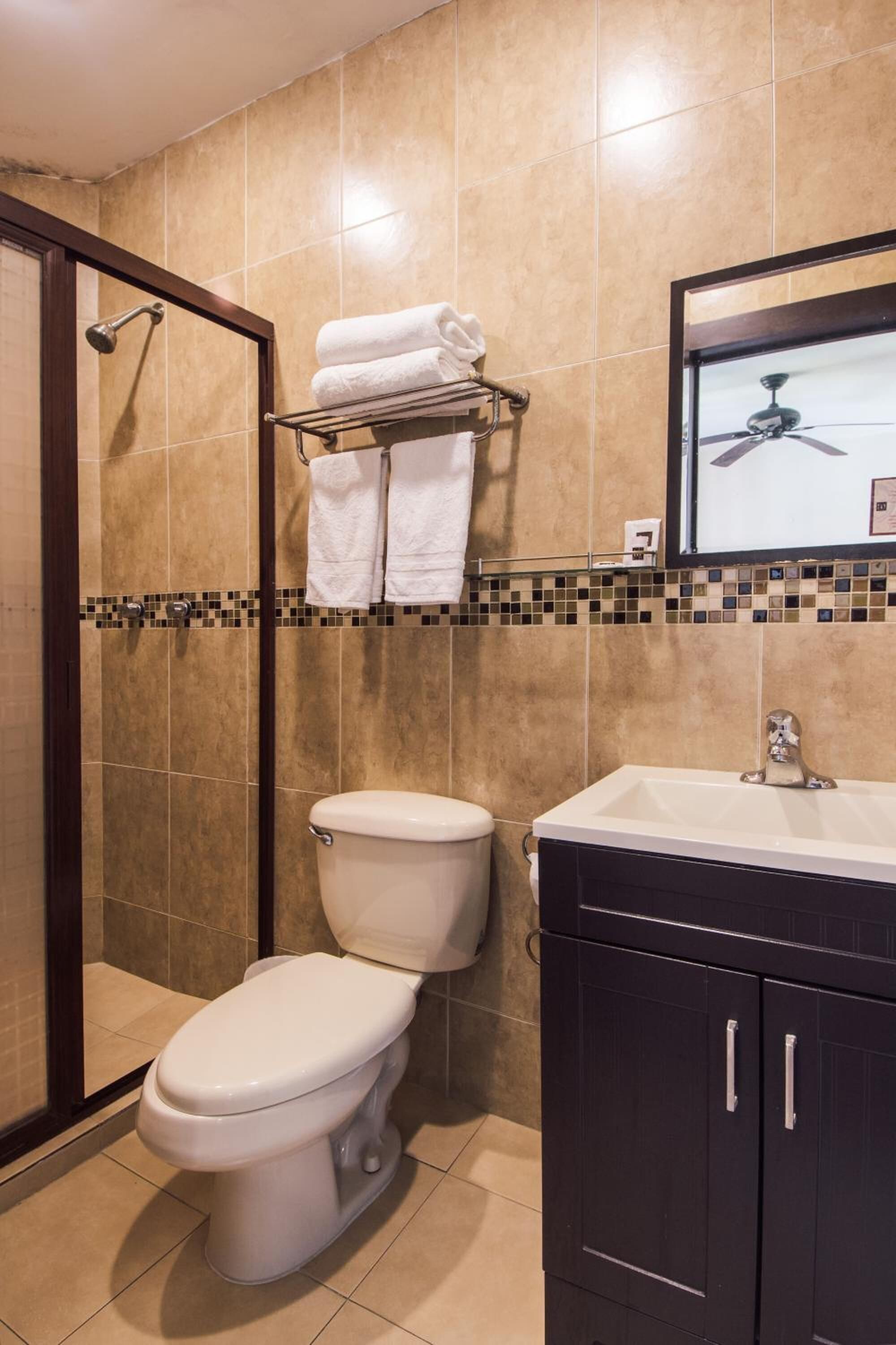 A bathroom with a shower, toilet, and sink.