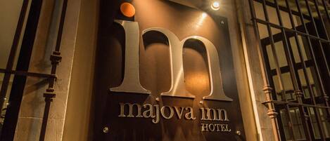 Señal para el Hotel Majova Inn, con una 'i' y una 'm' grandes en el centro y el nombre del hotel debajo.