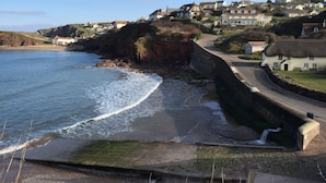 A coastal village with houses, a beach, and a sea wall. - The Sun Bay Hotel & Restaurant (Kingsbridge)