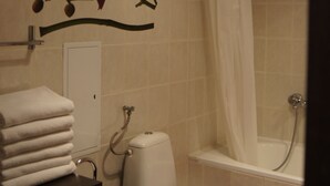 Une salle de bain avec des toilettes, un lavabo et une baignoire.