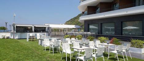 Terraza en la azotea con mobiliario exterior y una zona de bar, con vistas a un paisaje pintoresco.