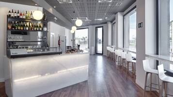 Een moderne bar met een centraal eiland, barkrukken en een wijnrek.