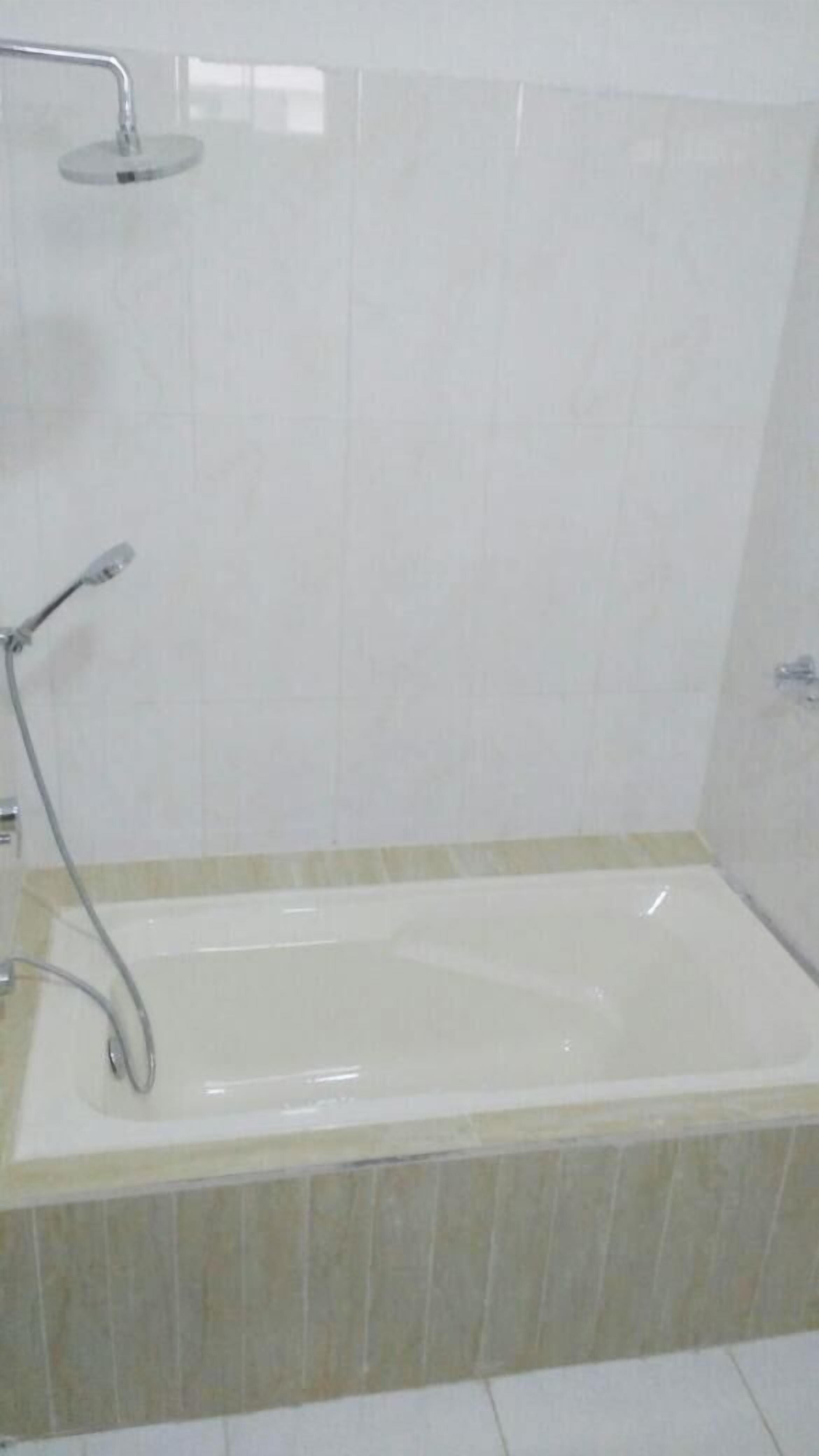 Une salle de bain avec une baignoire, une pomme de douche et un robinet.