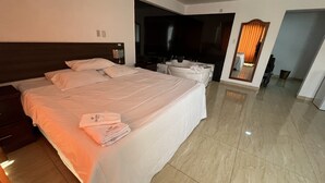 Une chambre d’hôtel avec un grand lit, une salle de bain et un miroir.