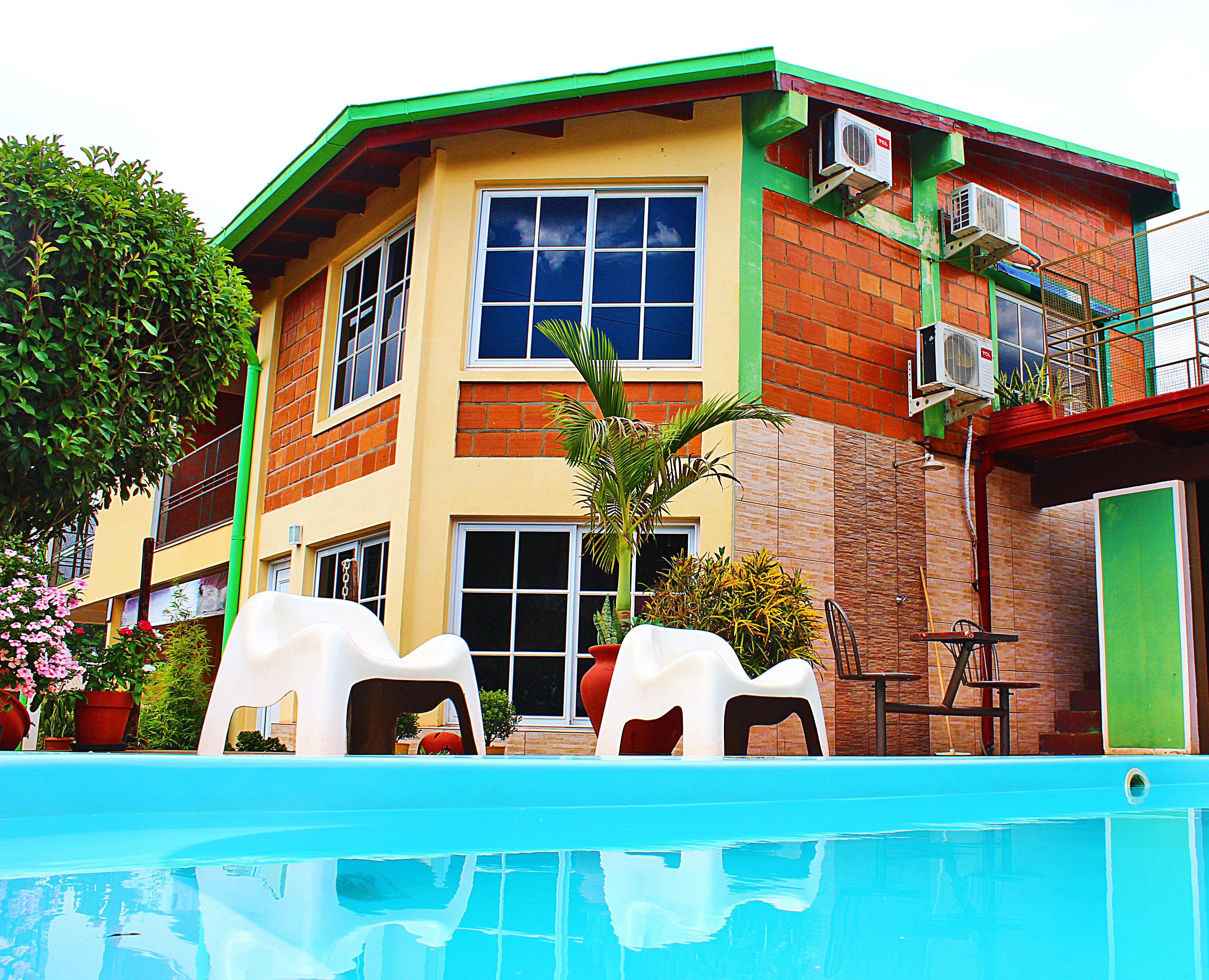 Una piscina al aire libre, sillones reclinables de piscina