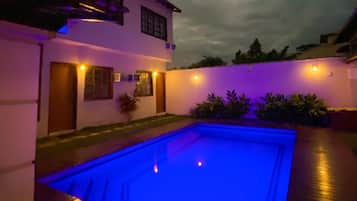 Alberca al aire libre y camastros