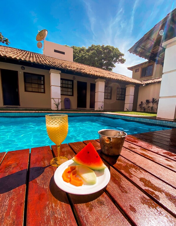Una piscina al aire libre, sillones reclinables de piscina