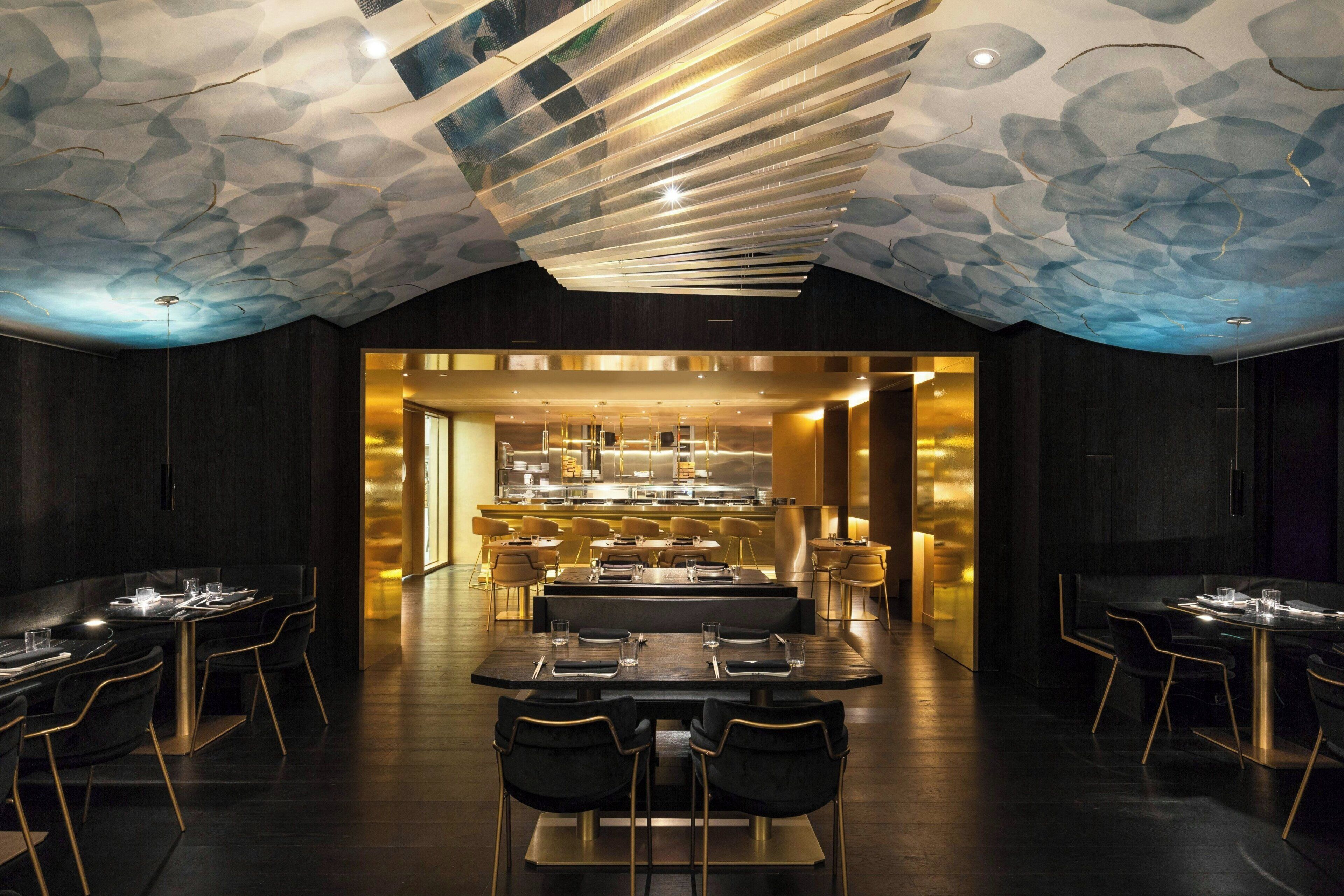 Un interior de restaurante moderno con una zona de comedor central, múltiples mesas y sillas.