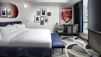 Ein modernes Hotelzimmer mit einem großen Bett, einem Schreibtisch und einem großen Fenster.