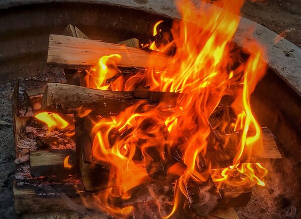 A fire burning inside a fireplace with logs and embers.