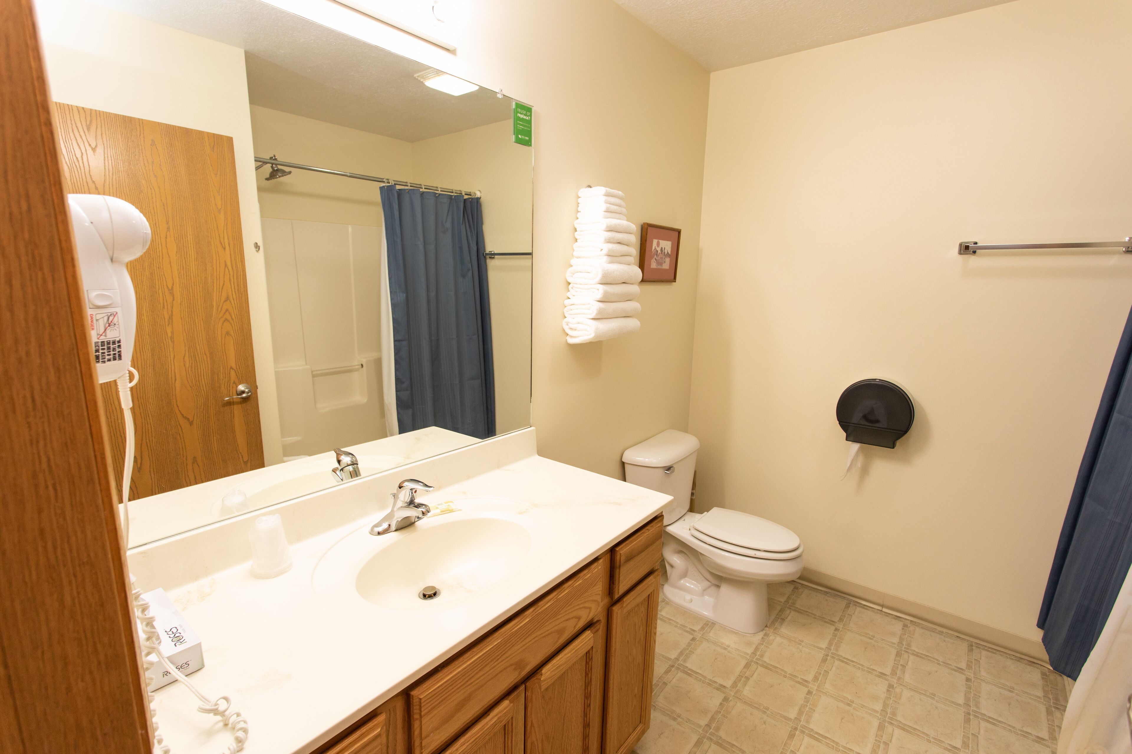 A bathroom with a sink, mirror, toilet, and towel rack.