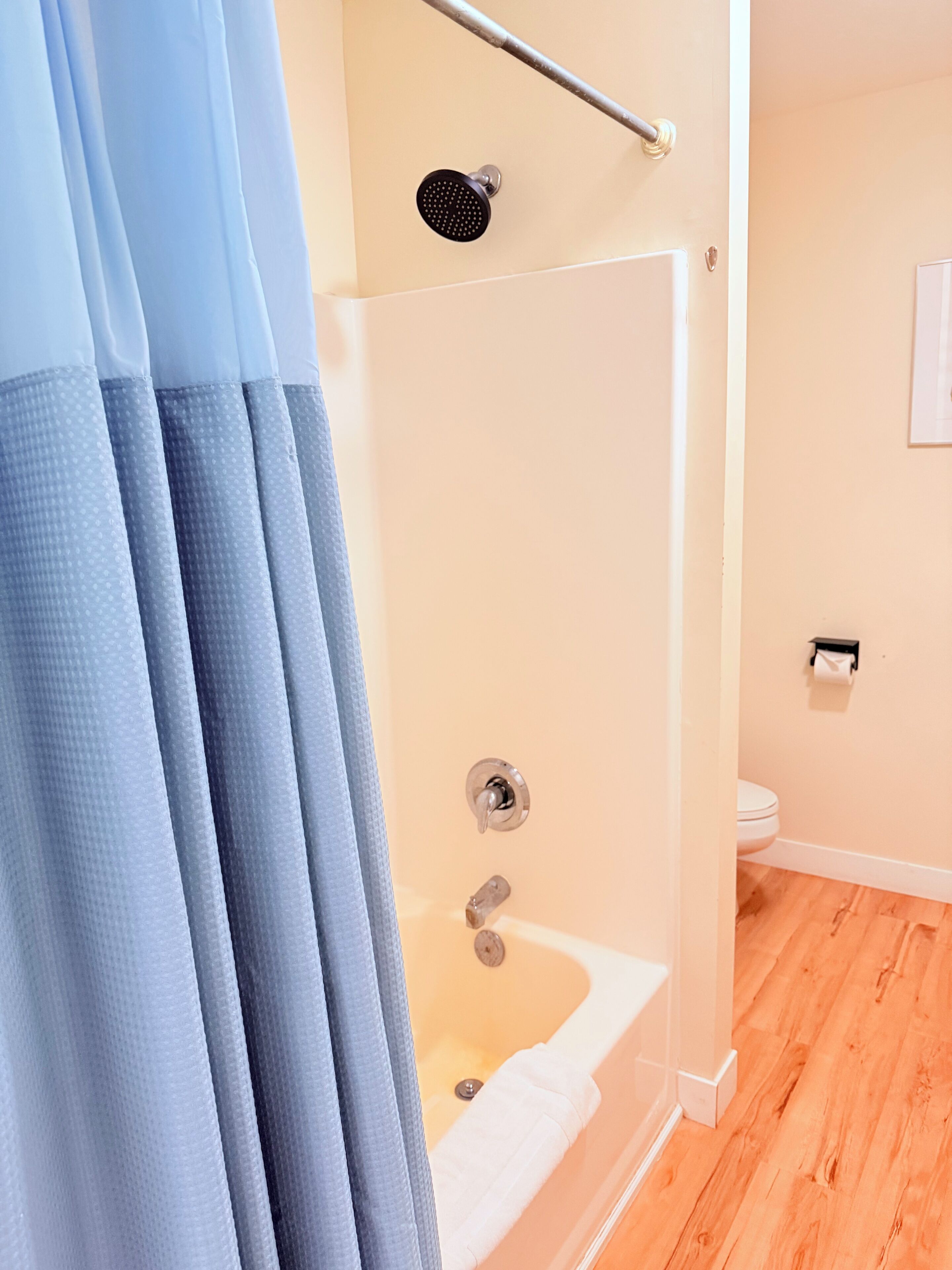 Een badkamer met douche, toilet en bad.