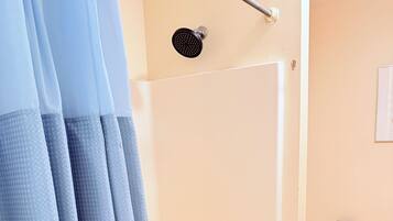 Een badkamer met douche, toilet en bad.