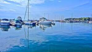 Ein Yachthafen mit verschiedenen vertäuten Booten, ruhigem Wasser und blauem Himmel.