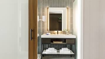 Un baño moderno con un espejo grande, un lavabo y un estante con toallas.