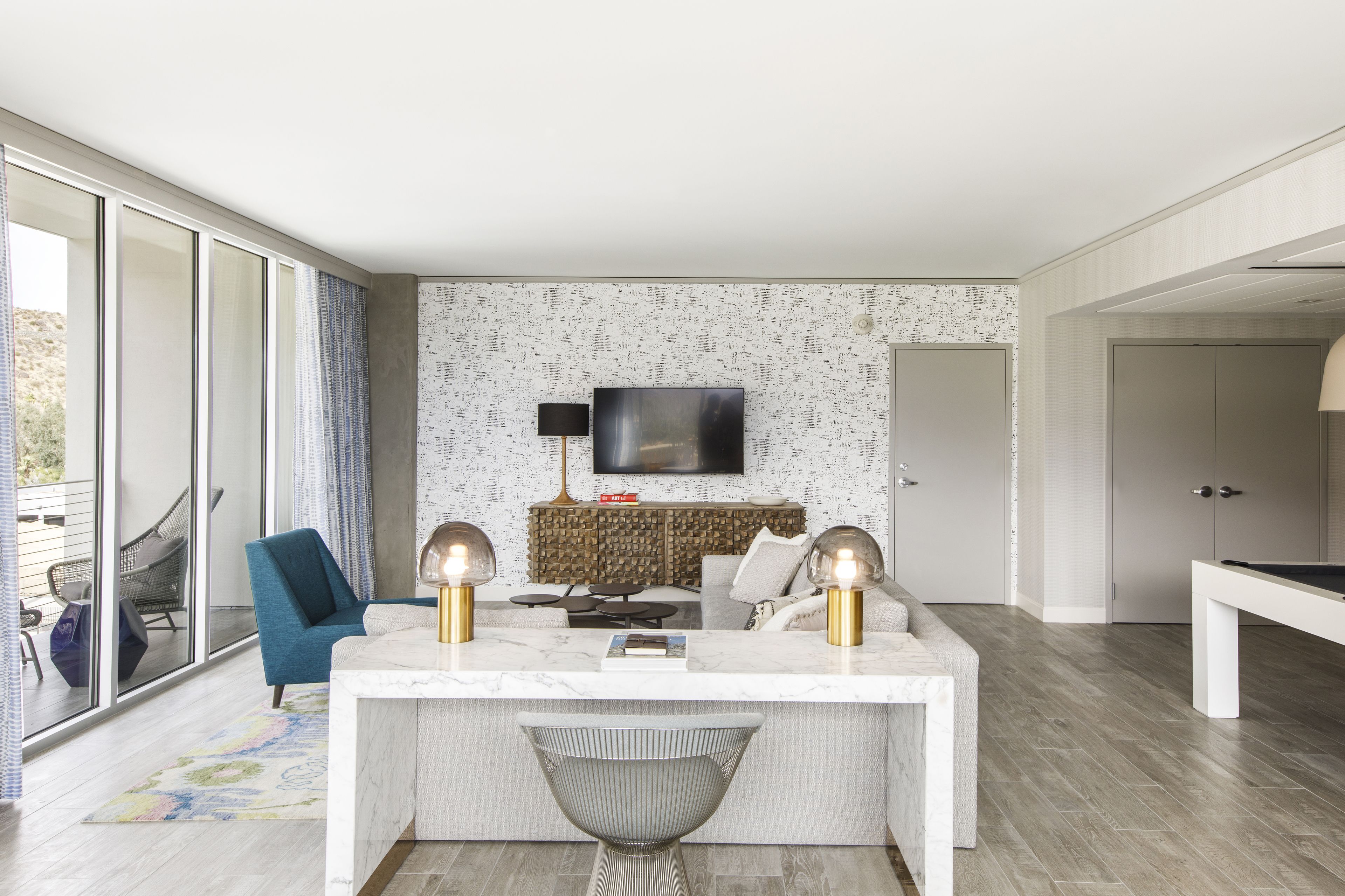 Un salon moderne avec une table basse en marbre, un canapé, un téléviseur et une table de billard.