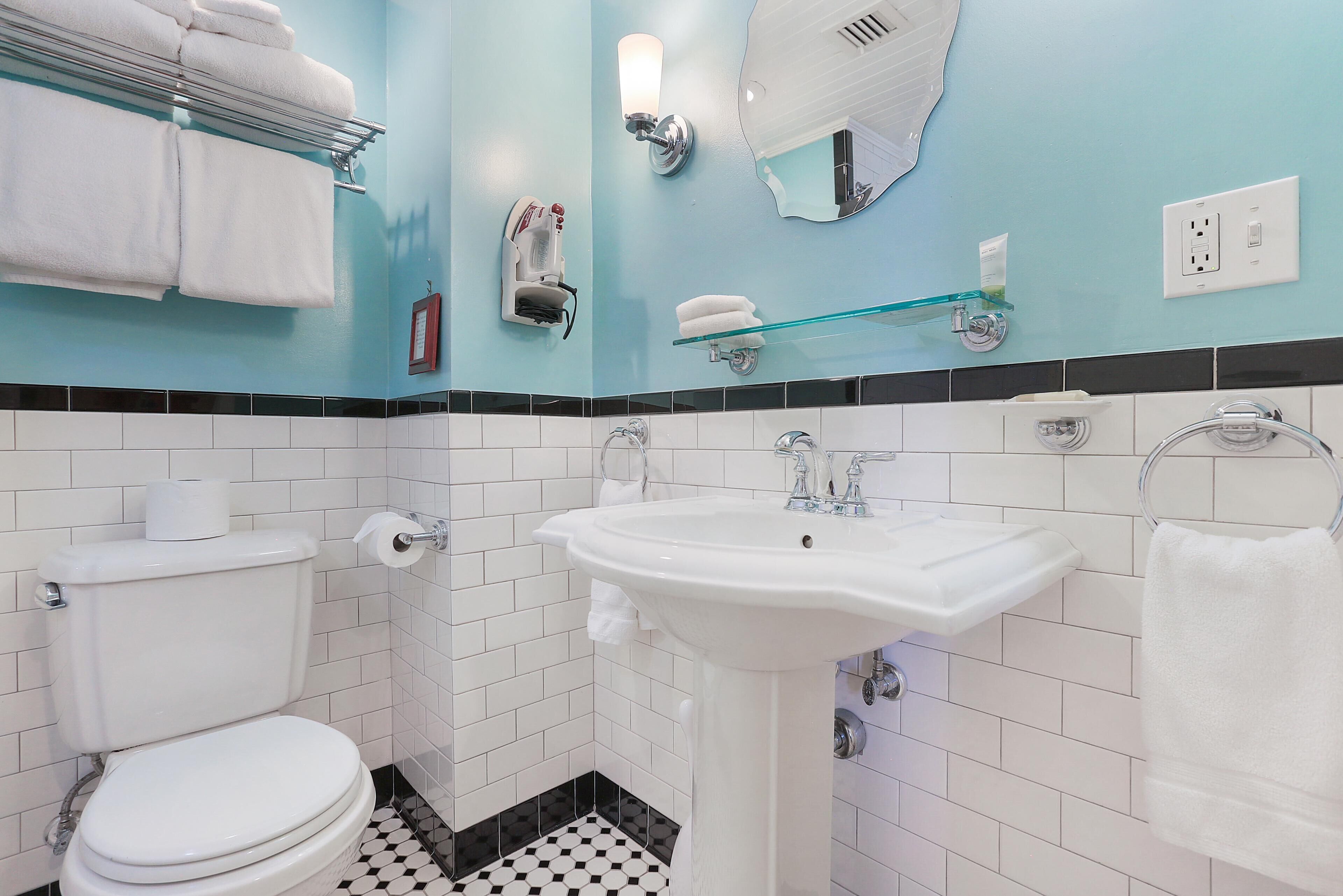 A bathroom with a white sink, a toilet, and a towel rack.