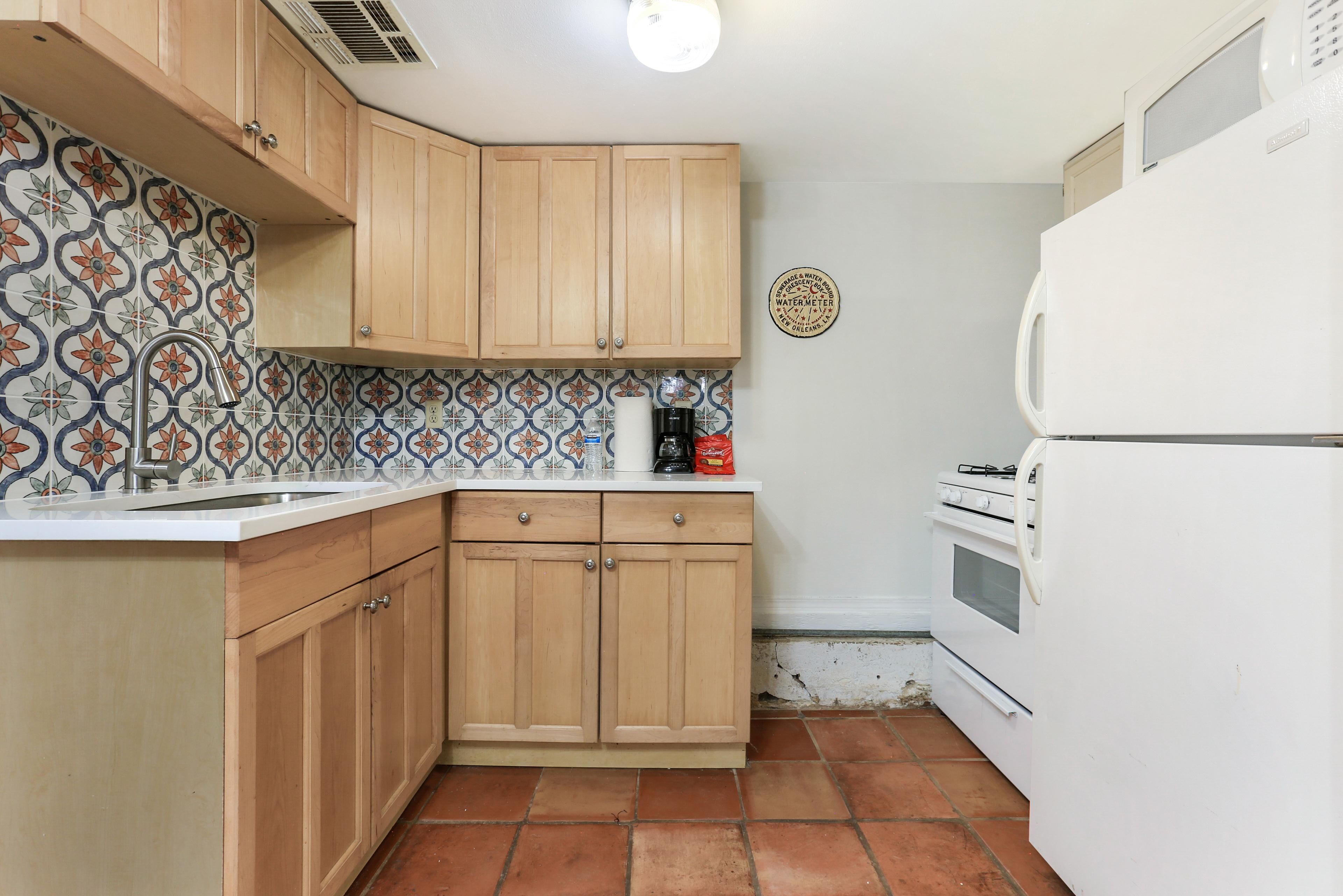 Una cocina con armarios de madera, un refrigerador blanco y un salpicadero decorativo.