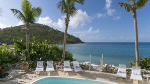 A pool area with lounge chairs and a view of the sea. - Coconut Coast Villas (St. John)