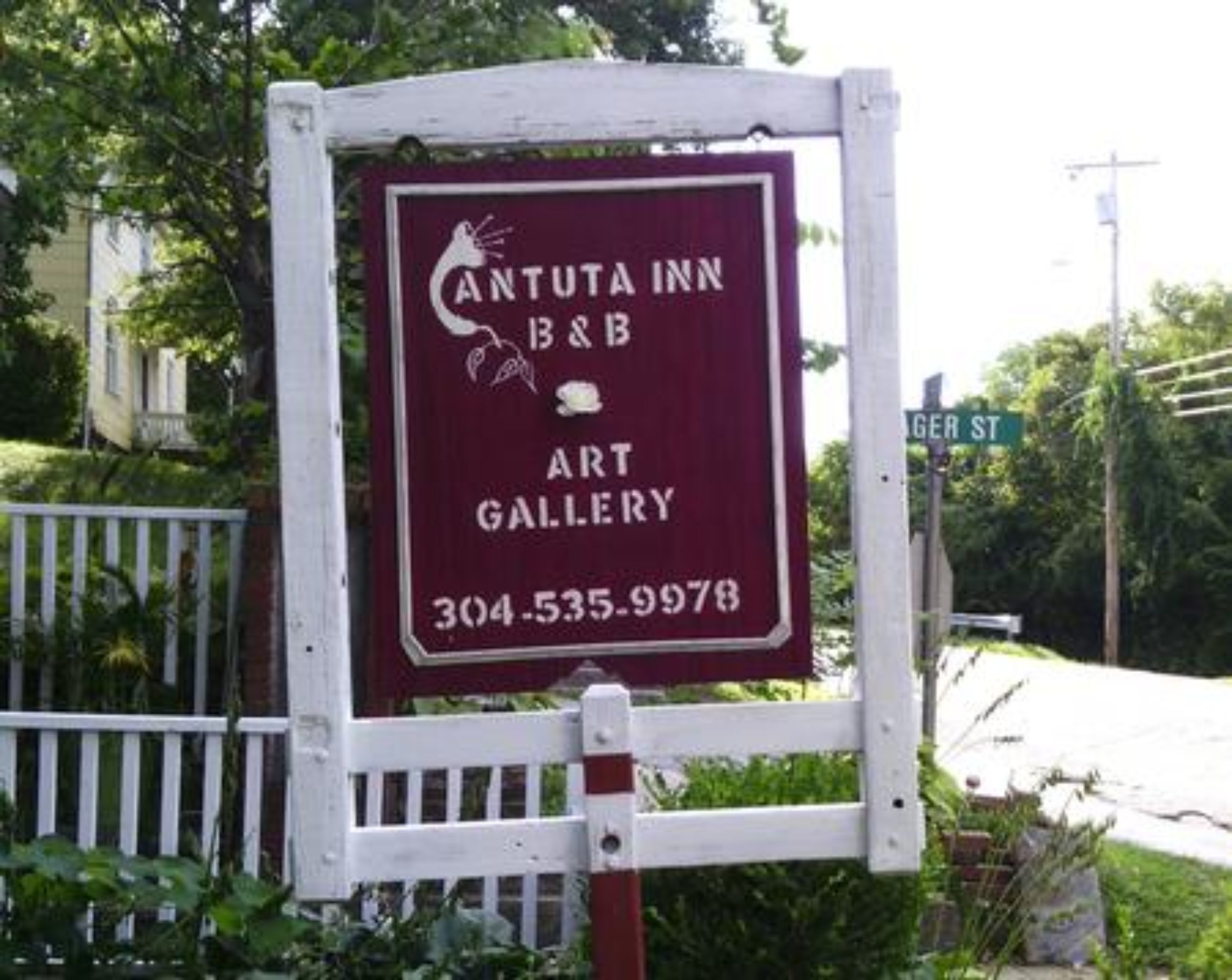 A sign for Cantuta Inn B&B Art Gallery with a contact number.