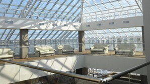 A spacious atrium with a glass ceiling, multiple levels, and seating areas. - Ramada by Wyndham Constanta (Constanta)