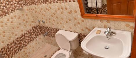 Un baño con suelo de baldosas, inodoro y lavabo.