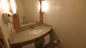 A bathroom with a sink, mirror, towel rack, and a hairdryer. - Samba Itaboraí (Itaborai)