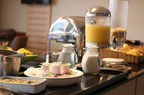 A breakfast buffet with various food items and a coffee machine.