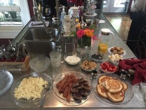 A breakfast buffet with various food items and a coffee station. - Fig Tree Manor (Palestine)