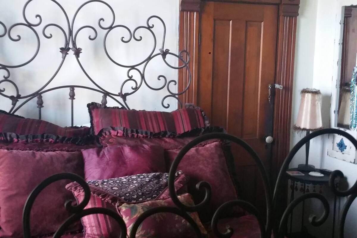 Un dormitorio con una cama, un armario de madera y un espejo.