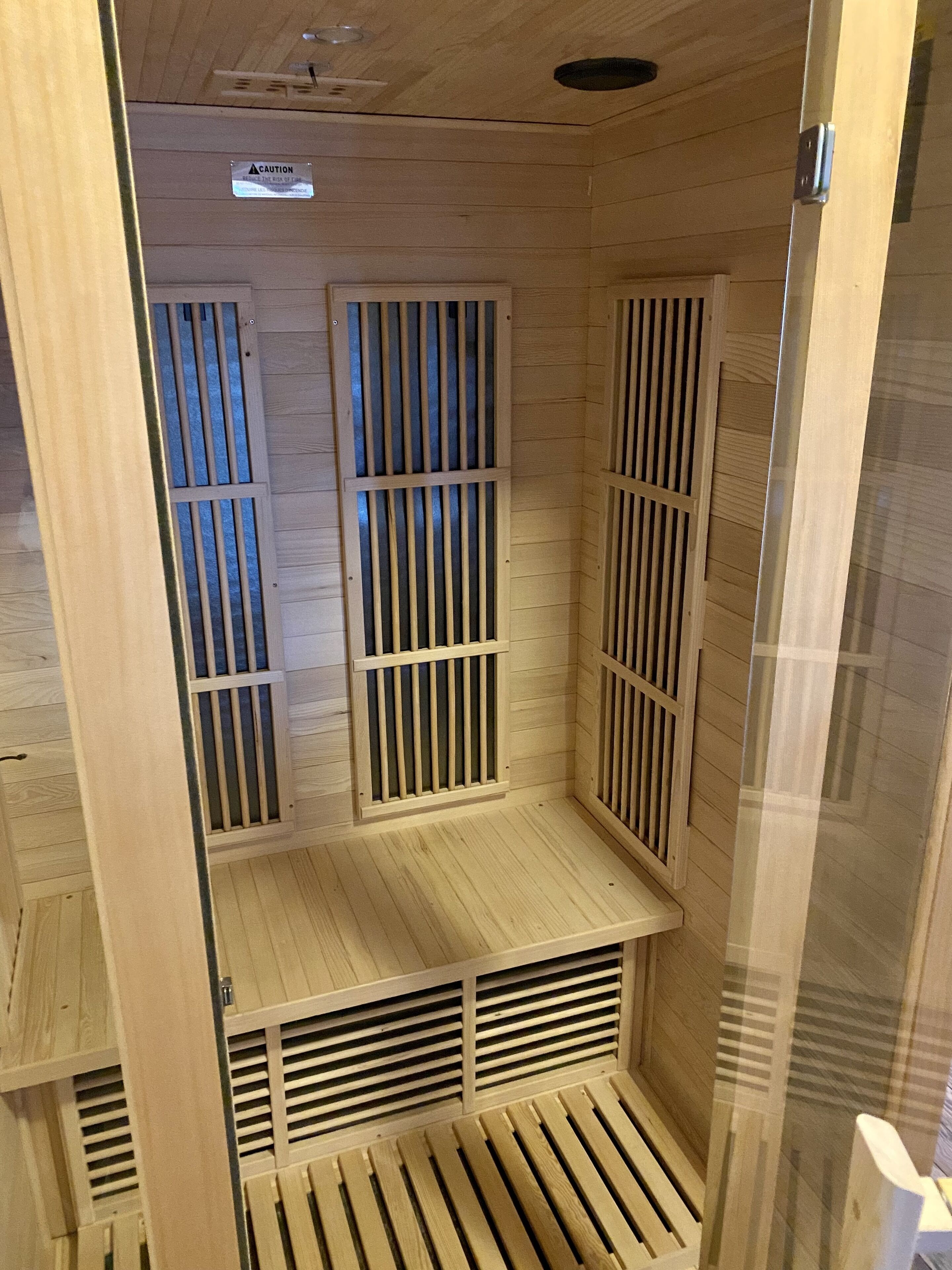 A sauna with wooden slats and a caution sign on the wall.