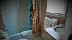 Un baño con bañera, inodoro y lavamanos.