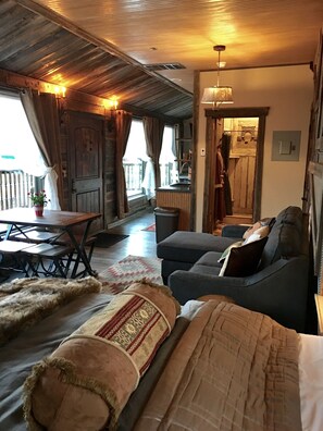 Um quarto acolhedor com sofá, mesa de jantar e cozinha.