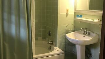 A bathroom with a shower, bathtub, sink, and toilet.