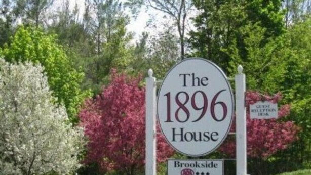 Een bord met de tekst 'The 1896 House' en het logo van Brookside Accommodations.