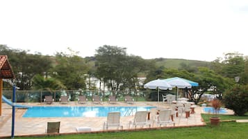 Una piscina al aire libre, sombrillas, tumbonas