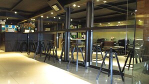 Un espacio de oficina moderno con divisiones de vidrio, mobiliario metálico y un ambiente limpio y bien iluminado.