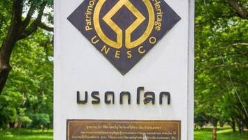 A UNESCO World Heritage sign with a plaque in a park.