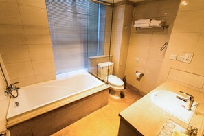 A bathroom with a bathtub, toilet, and sink. - World City Jiamei Service Apartment (Beijing)