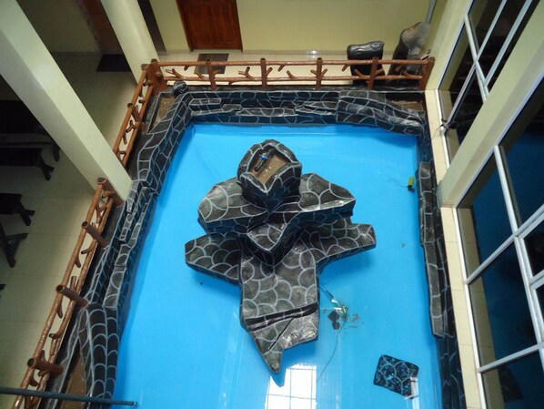 A large indoor pool with a unique geometric design, surrounded by a wooden deck. - Kings Hotel Restaurant & Bar (Trincomalee)