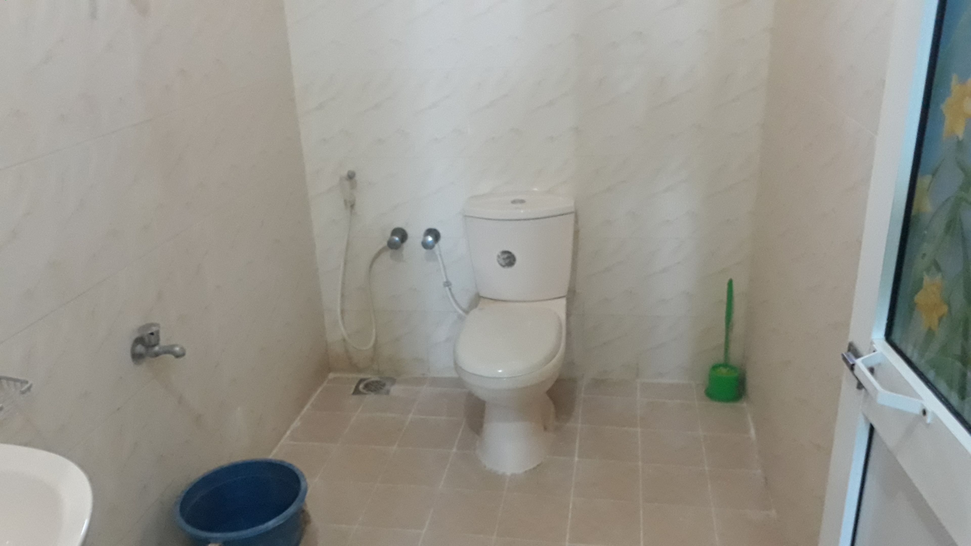 A small bathroom with a toilet, a shower, and a sink.