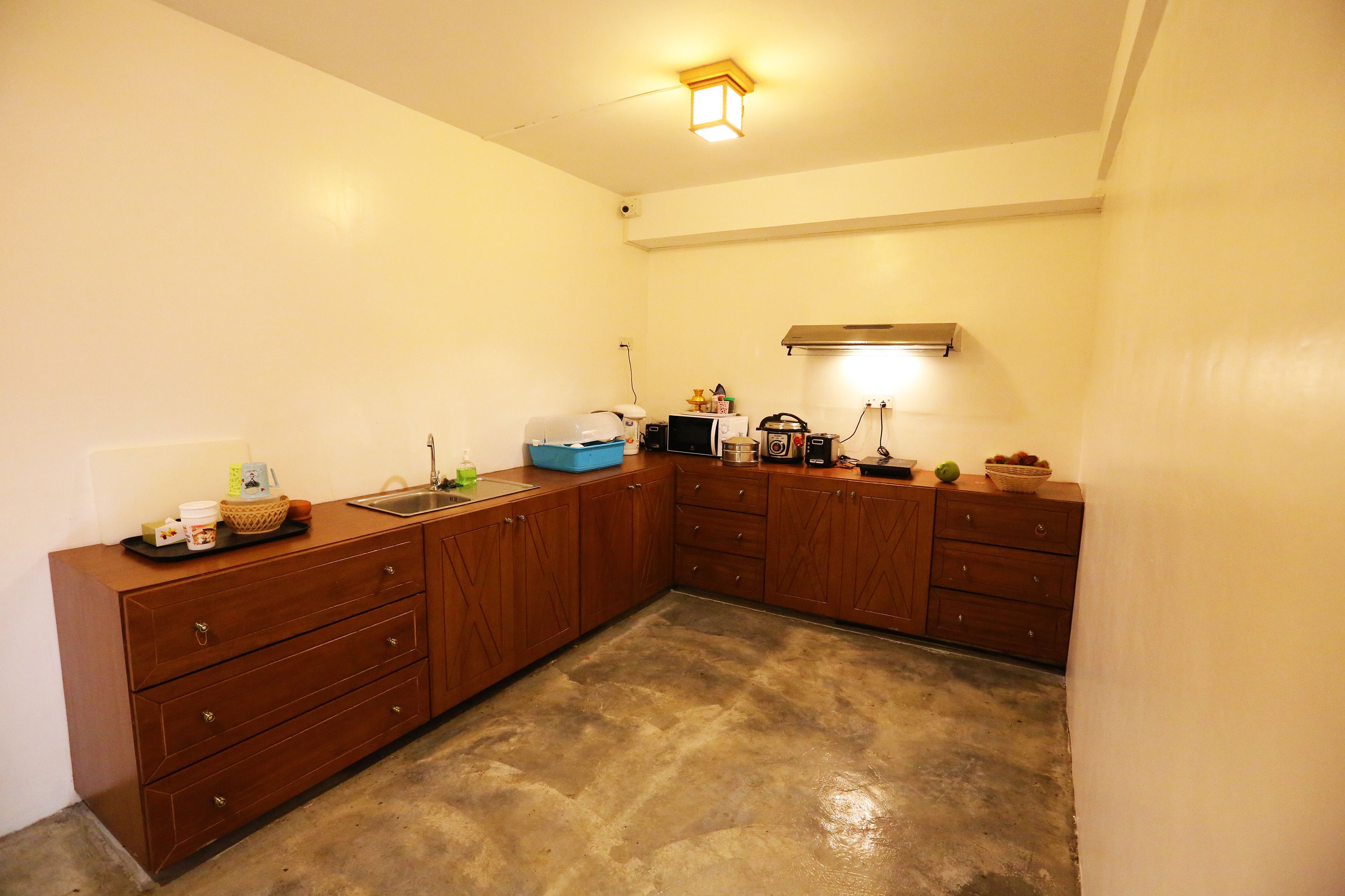 A compact kitchen with wooden cabinets, a sink, and a microwave.