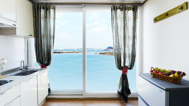 Eine Küche mit großem Fenster, Spüle und Kühlschrank.